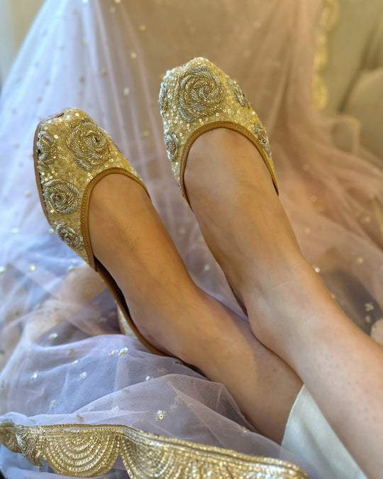 Gold embellished shoes worn with a white outfit